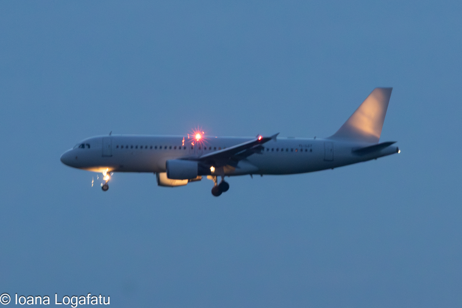 Airplane approaches landing during twilight skies